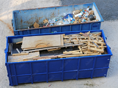blue dumpster full of wood waste