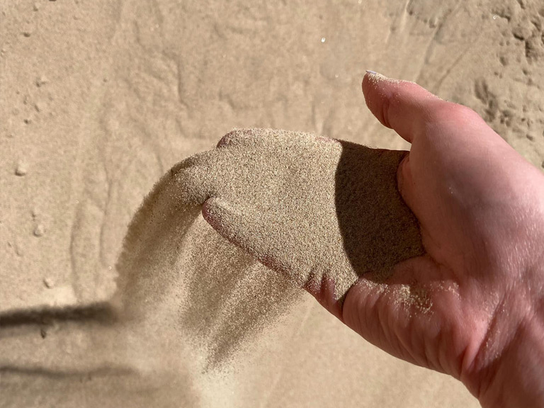 hand picking up play sand