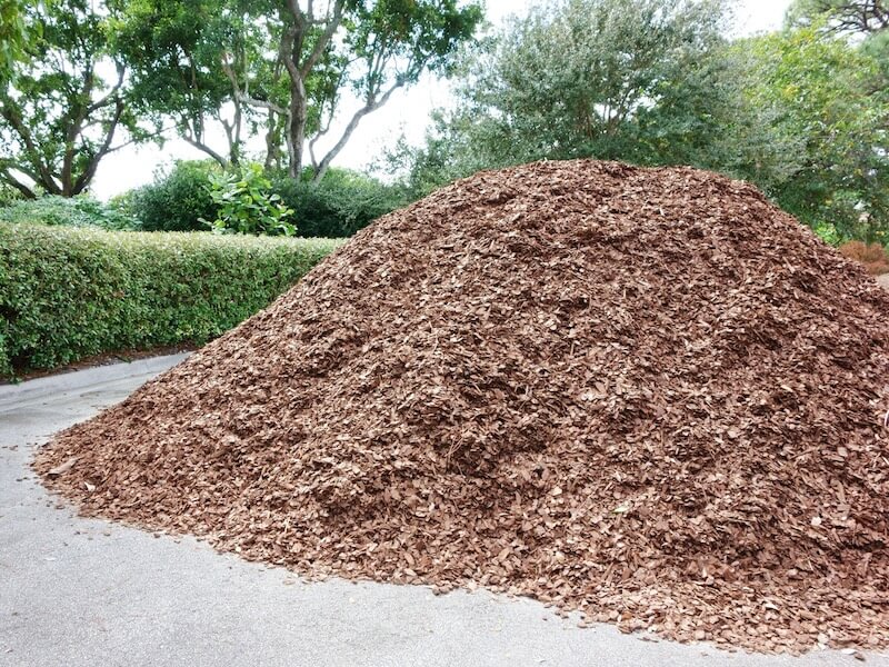 pile of brown mulch on driveway